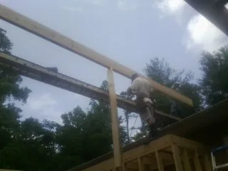 Carpenter setting a ridge beam over a new addition frame — Ice Dam Removal by Roofing Brothers in Yorkshire