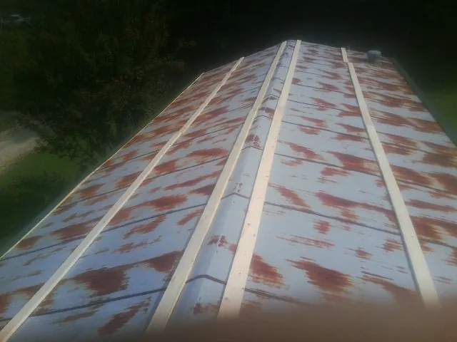 Rusted metal roof panels with new wood purlins before replacement — Storm Damage Roof Repair in Yorkshire by Roofing Brothers